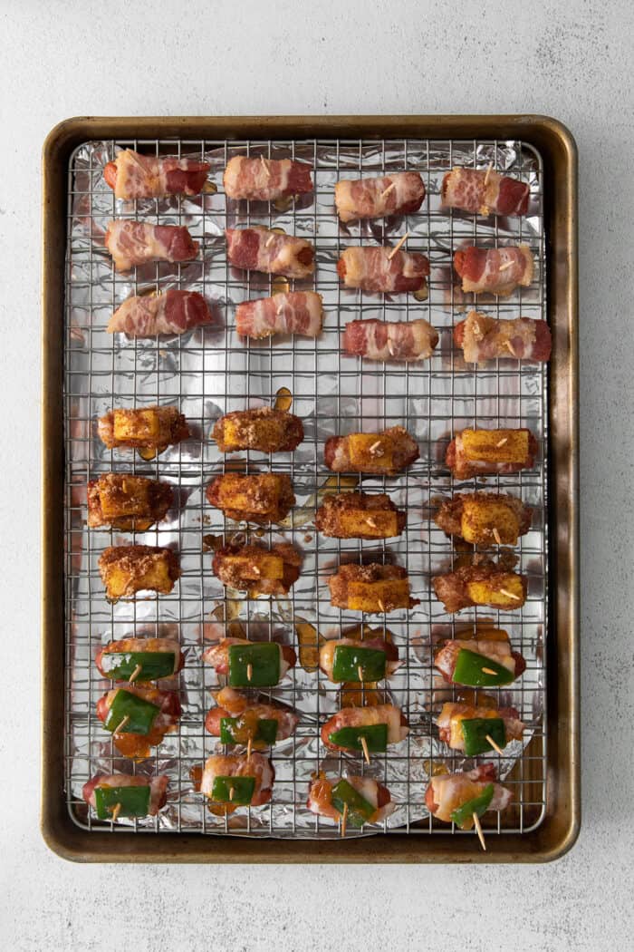 Overhead view of bacon wrapped smokies on a baking sheet