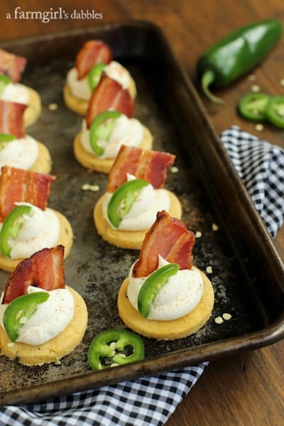 Corn Cakes topped with Honey Whipped Goat Cheese, bacon, and a slice of jalapeño 