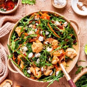 North African cauliflower salad in serving bowl with spoon.