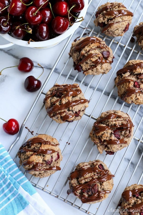 Dark Cherry Scones with Chocolate-Chili Glaze on a cooling rack with a bowl of cherries