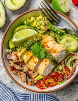 Grilled chicken salad in bowl topped with cilantro lime vinaigrette