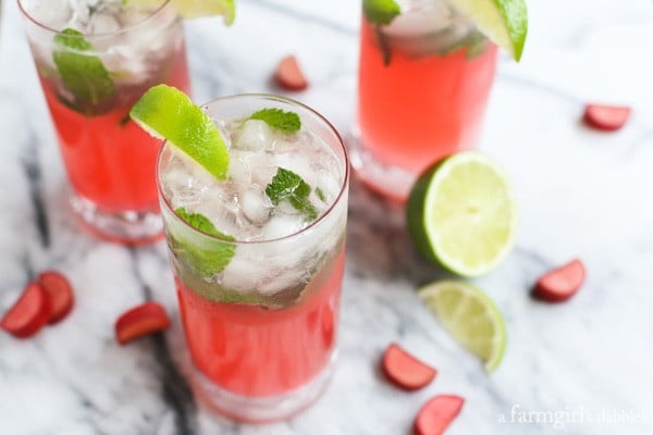 Rhubarb Mojitos with mint and lime wedges
