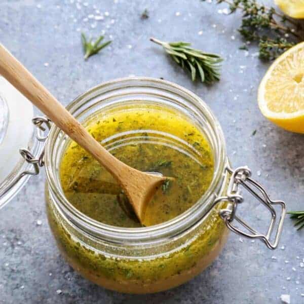 a clear jar of herby lemon vinaigrette