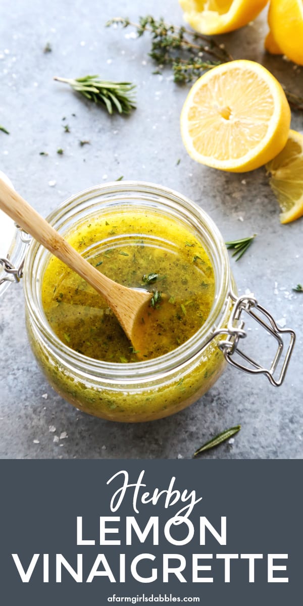 pinterest image of herby lemon vinaigrette in a jar with fresh lemon in the background