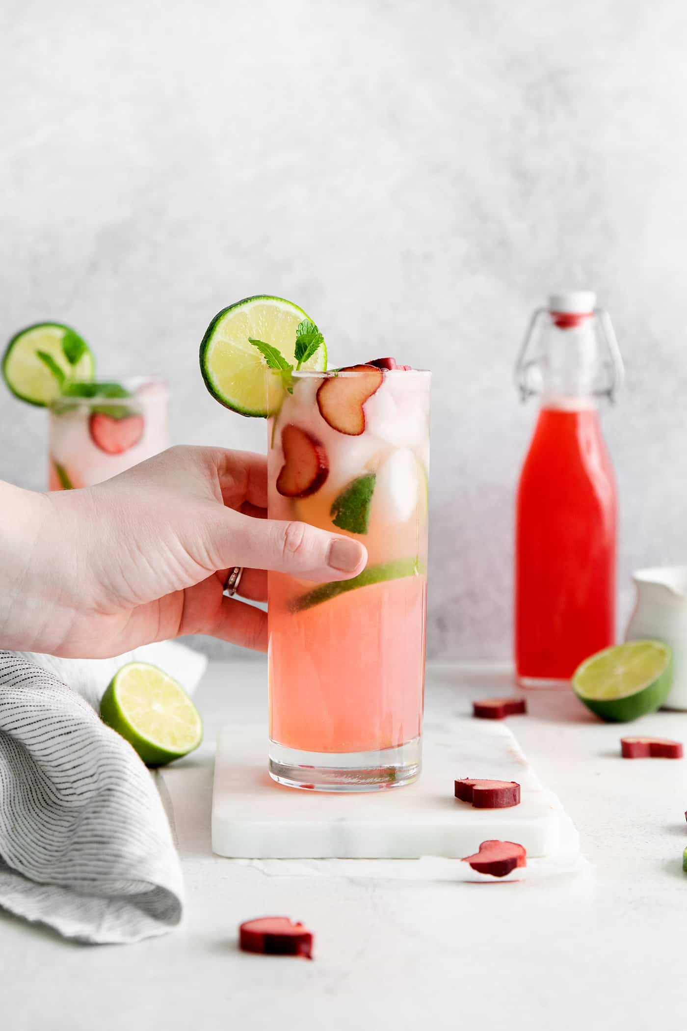 A hand grabbing a rhubarb mojito