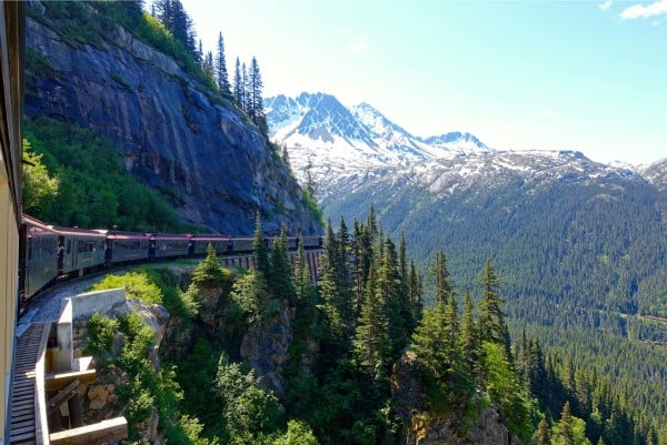 a train going through mountains in Skagway, Alaska