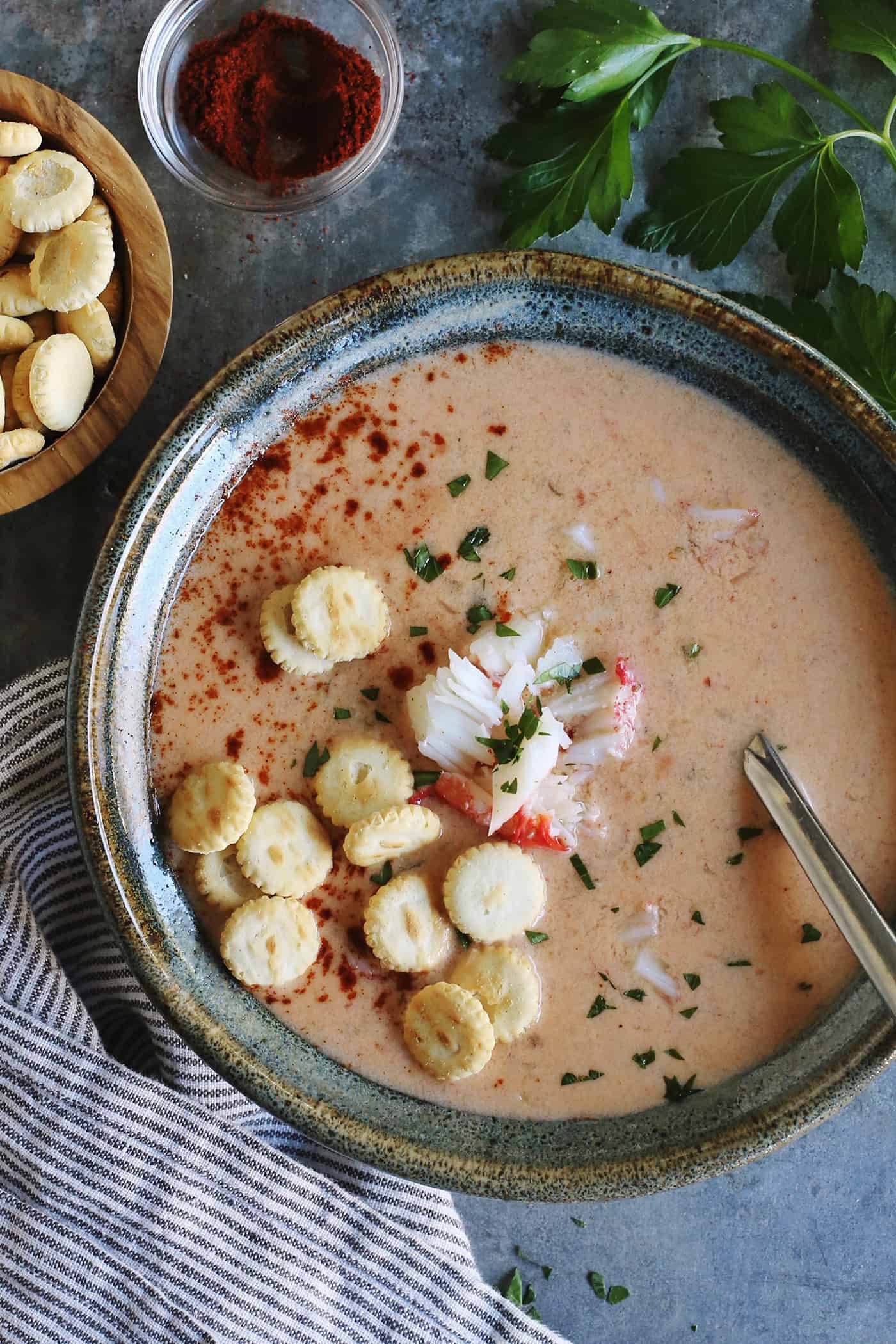 Overhead view of a bowl of crab soup topped with oyster crackers
