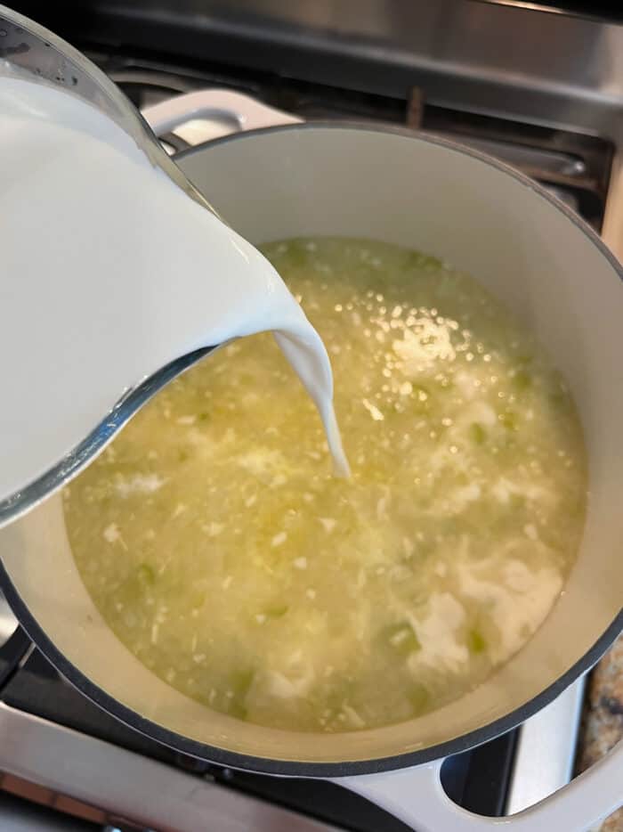 Cream being added to seafood broth