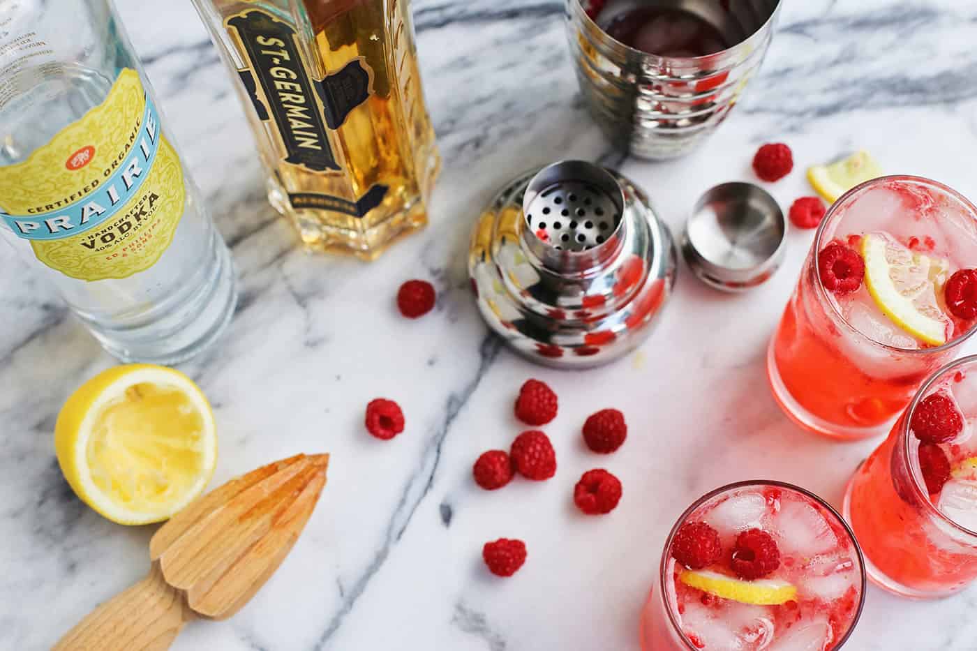 Overhead view of three raspberry smash cocktails and the ingredients needed