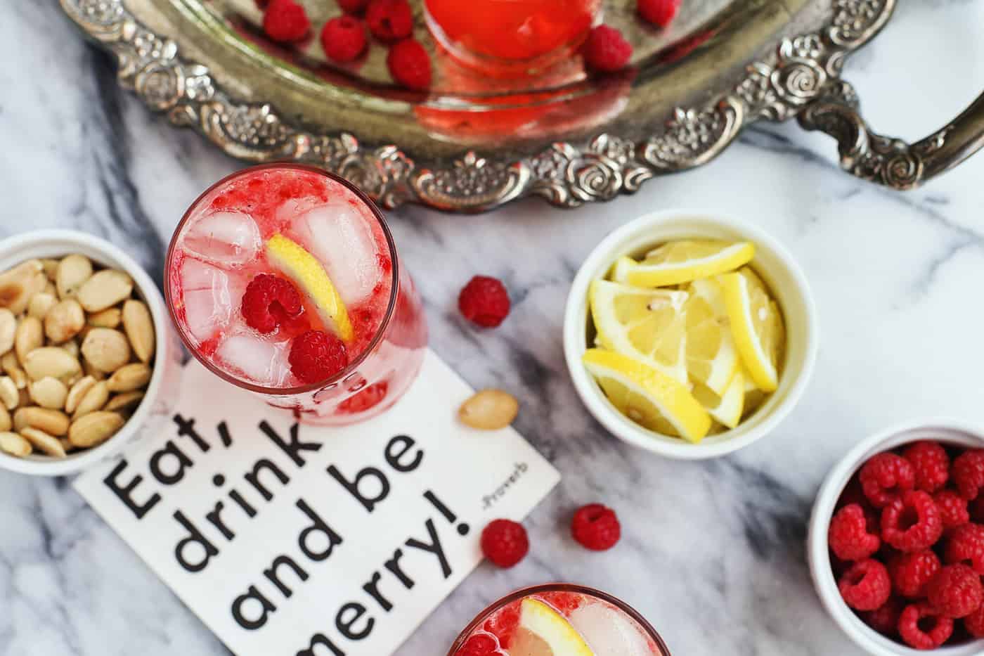 Overhead view of a dish of lemon slices and a raspberry vodka cocktail