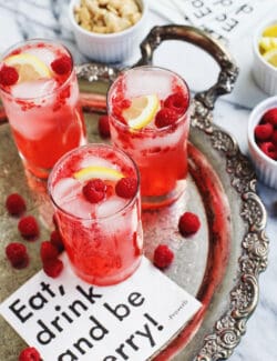 3 glasses of raspberry smash, garnished with lemon and fresh raspberries