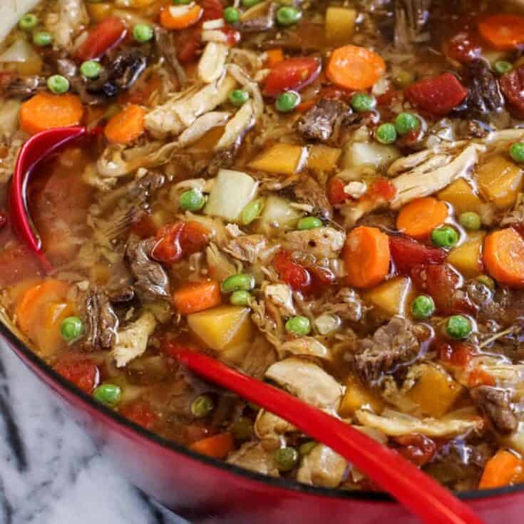 booya stew in a red pot with a red ladle