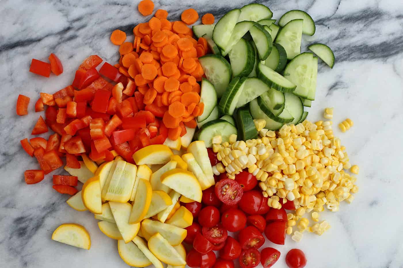 Chopped vegetables - tomatoes, cucumbers, corn, peppers, carrots and squash