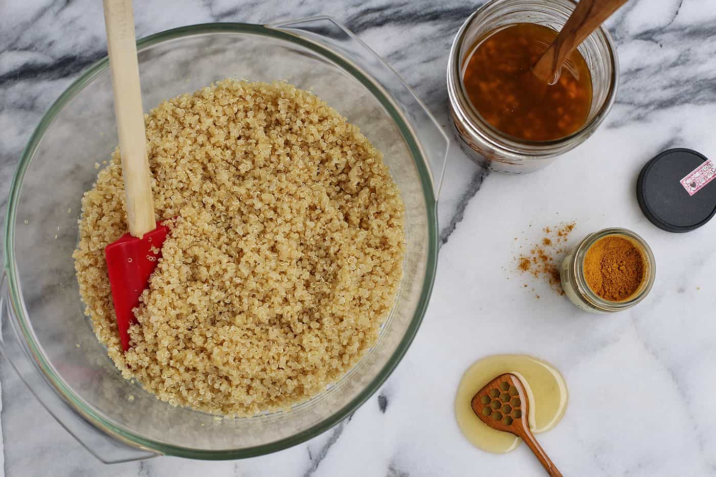 Quinoa in a glass bowl and several seasonings measured out