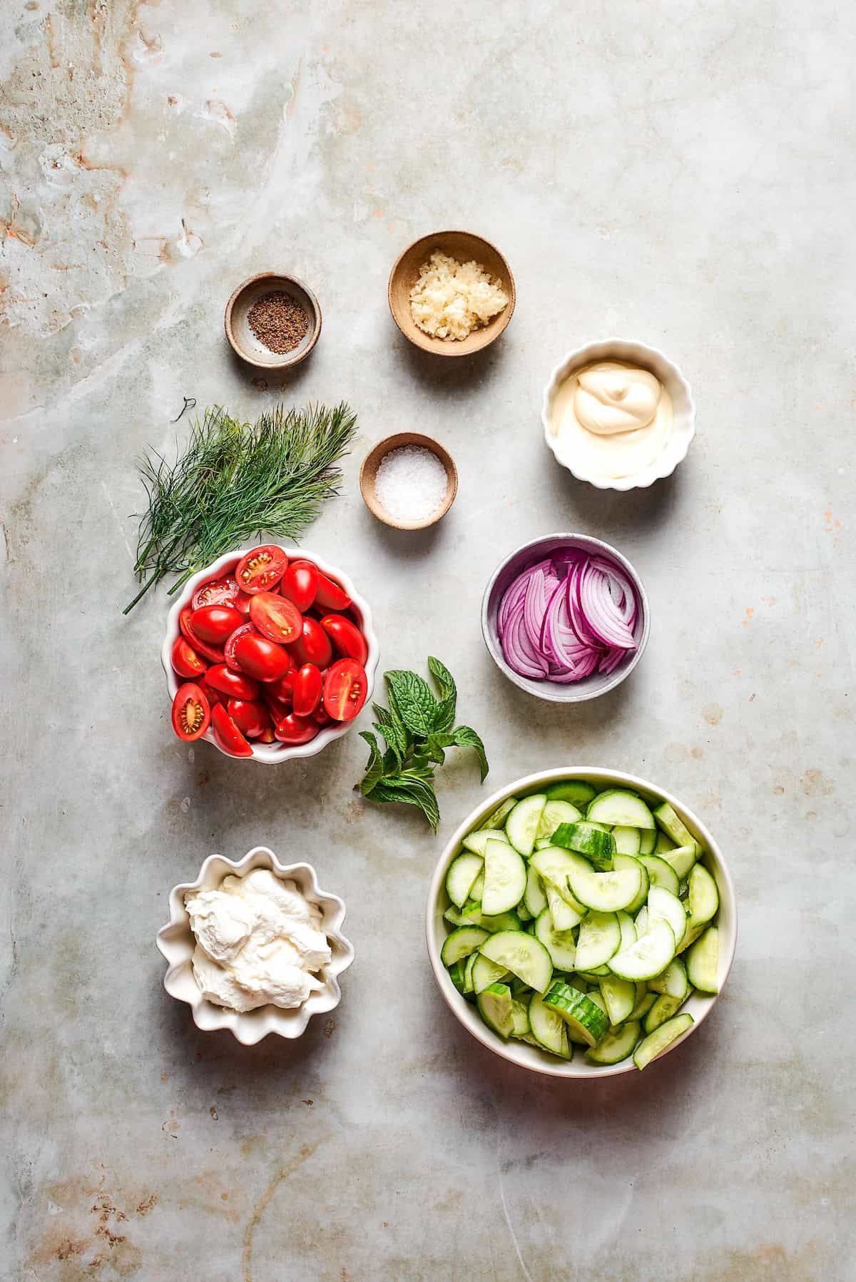 With fresh vegetables and a creamy herbed dressing, this cucumber and tomato salad is the perfect goes-with-anything side dish for summer. Ingredients for cucumber and tomato salad with creamy herb dressing.