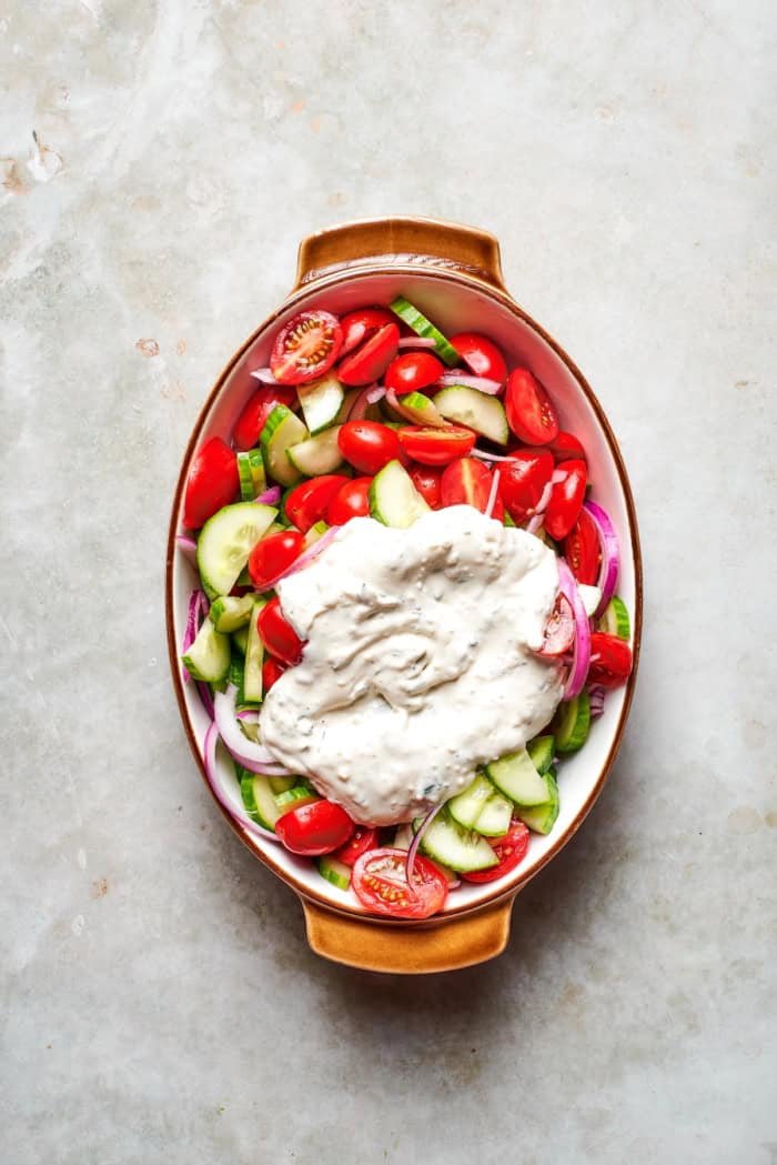 With fresh vegetables and a creamy herbed dressing, this cucumber and tomato salad is the perfect goes-with-anything side dish for summer. Creamy dressing added to cucumbers, tomatoes, and red onion.