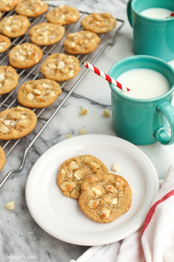 Cookies on a cooling rack with two mugs of milk