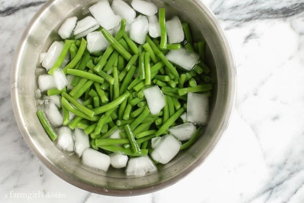 fresh green beans in an ice water bath