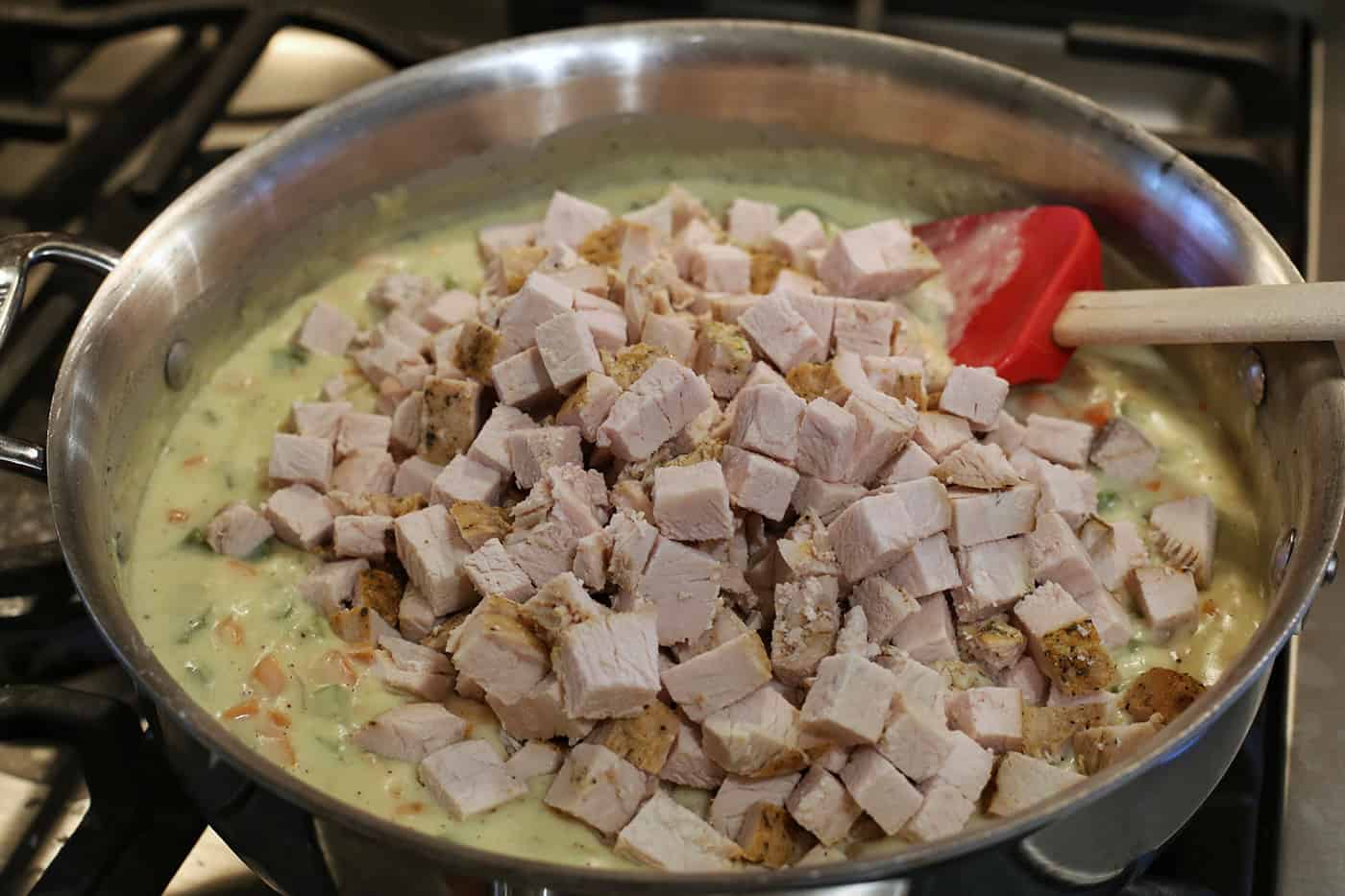 Turkey chunks being mixed into vegetable gravy