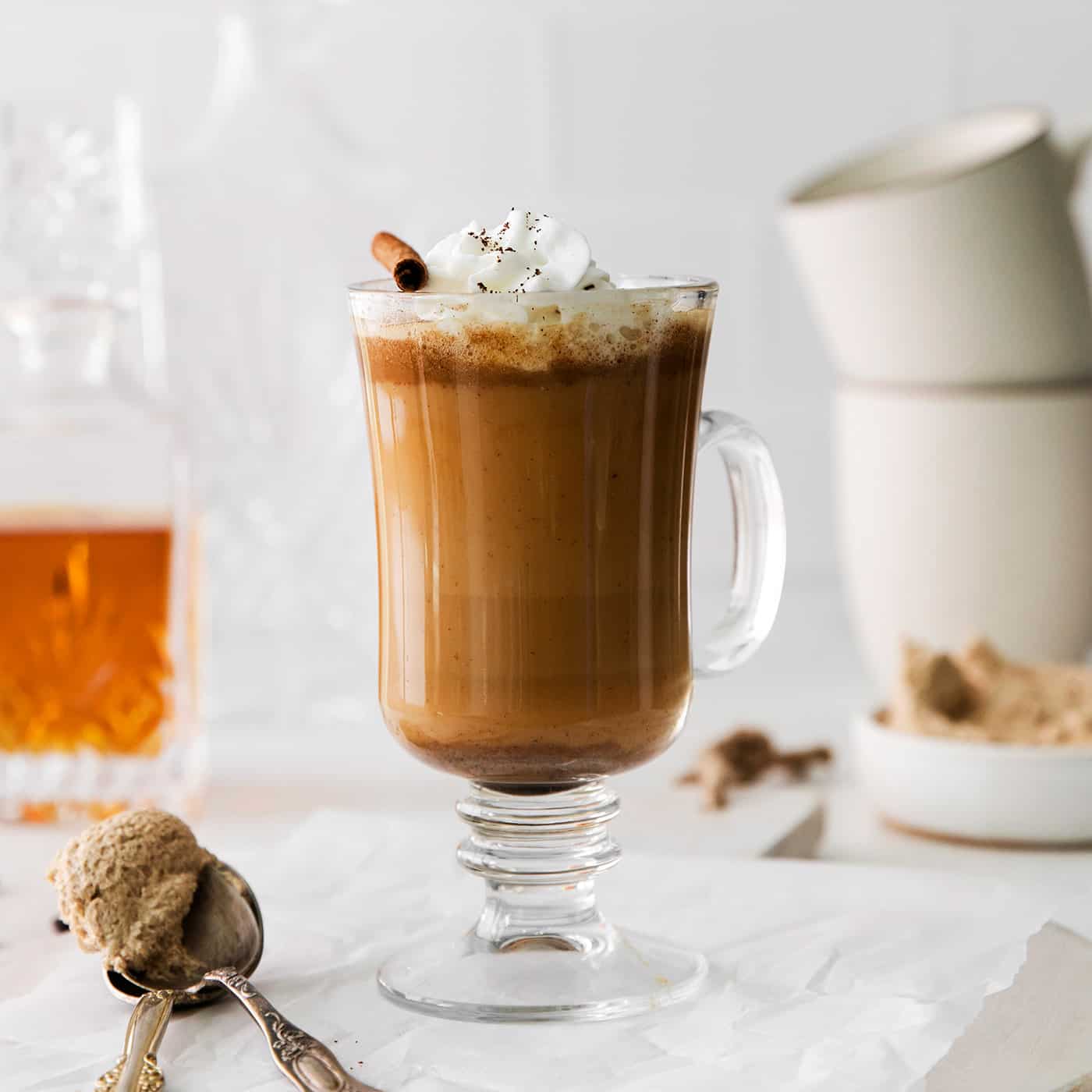 A hot buttered rum coffee garnished with whipped cream