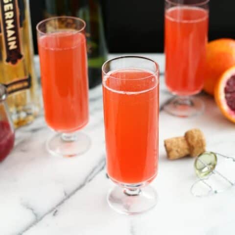 Three cocktail glasses of Blood Orange Mimosas