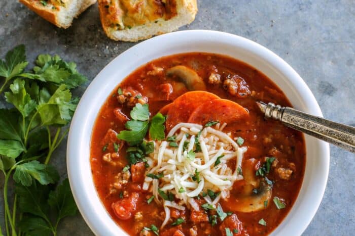 soup with pepperoni and sausage in a white bowl