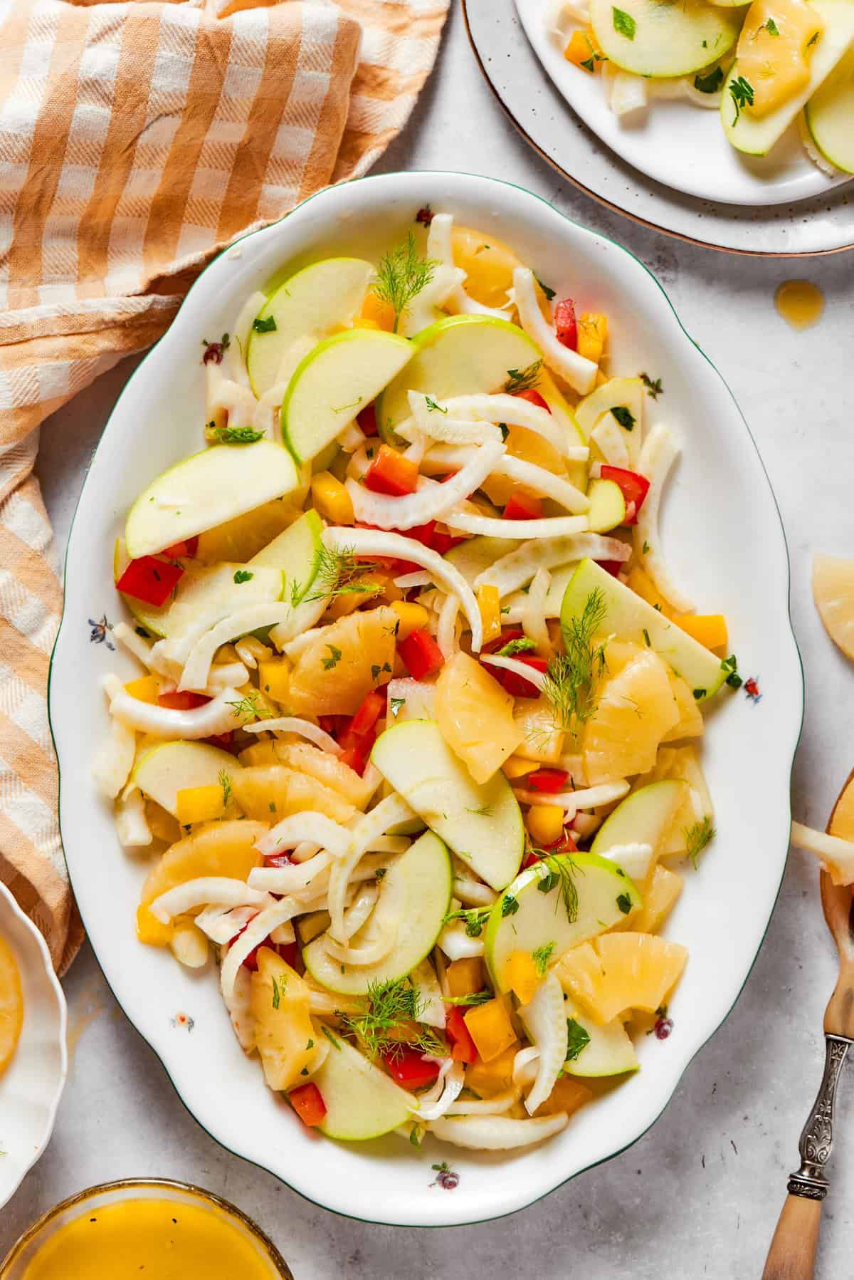 This fresh, crisp Fennel Apple Salad with pineapple, bell peppers and ginger dressing is an easy, vibrant side dish perfect for any meal! Platter of fennel apple salad with ginger dressing.