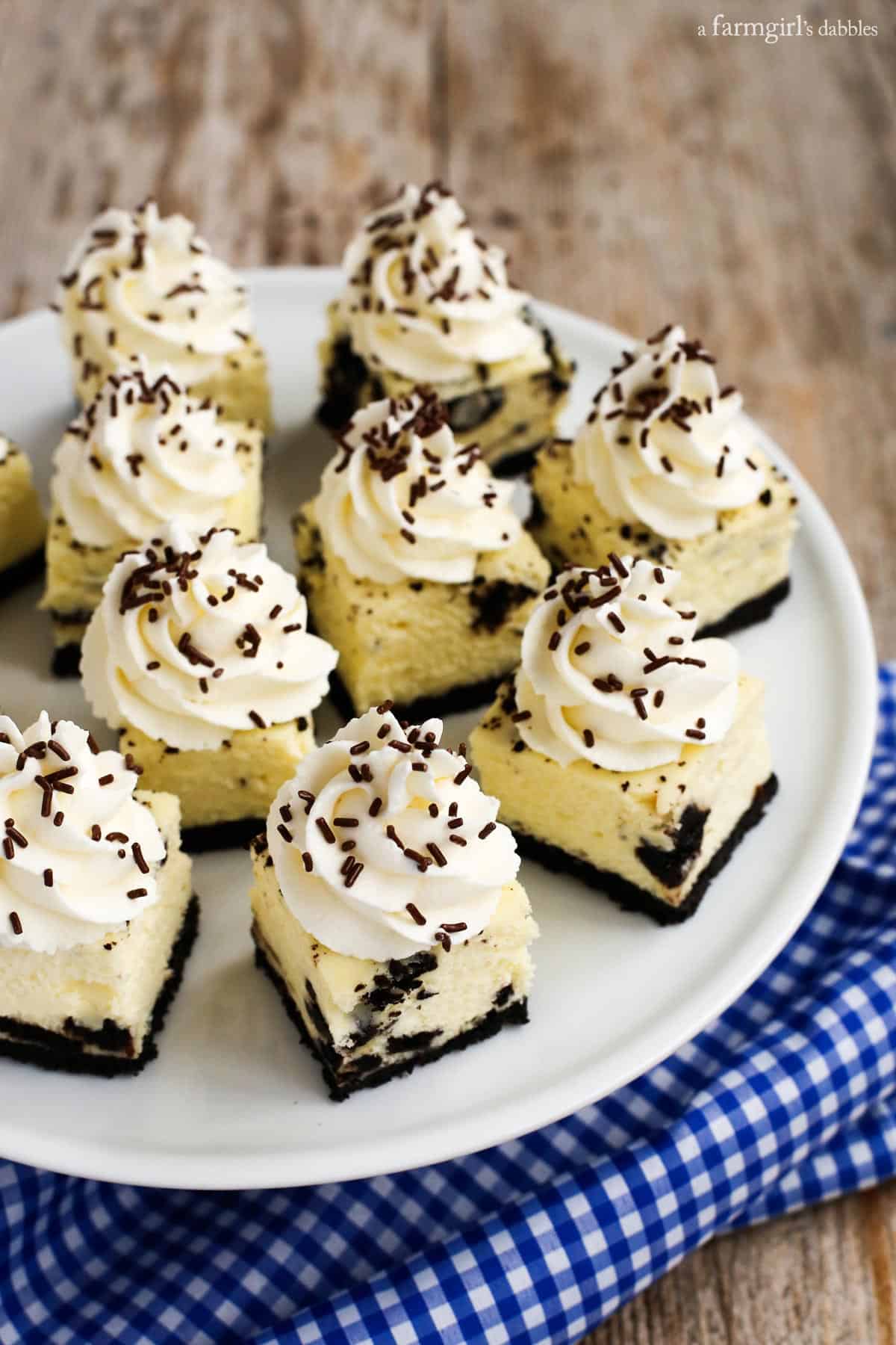 A plate of Oreo Cheesecake Bites with whipped cream and brown sprinkles 
