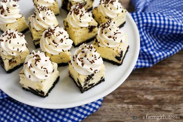 A plate of Oreo Cheesecake Bites on a white plate and blue cloth