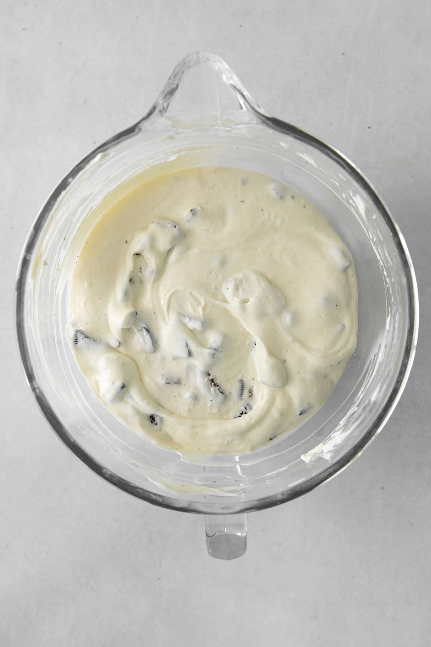 Oreo cheesecake filling in a glass mixing bowl