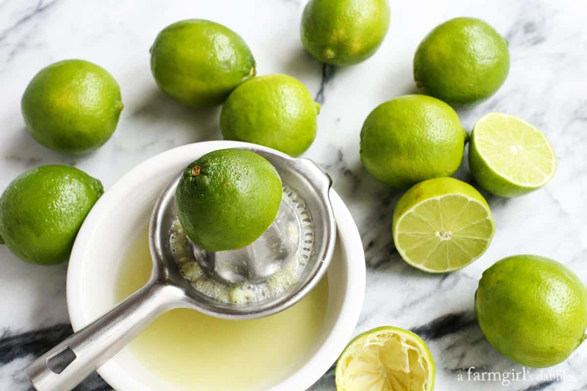 Limes being squeezed into a bowl