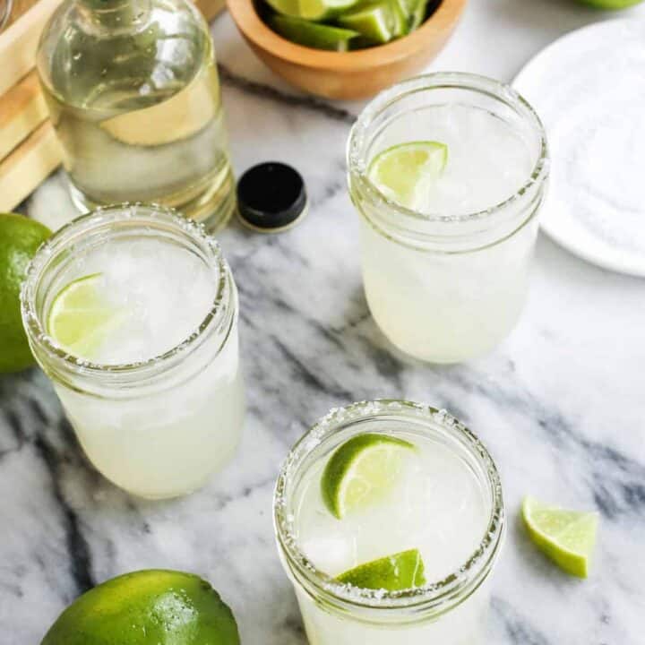 three mason jars of Margarita with simple syrup and limes