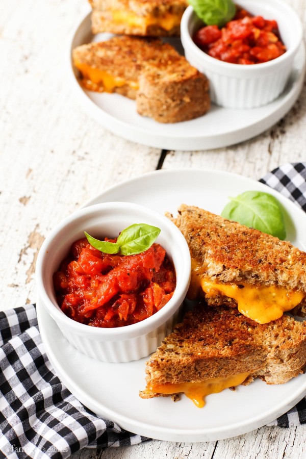 Spicy Italian Tomato Grilled Cheese Dip on a plate with a grilled cheese sandwich