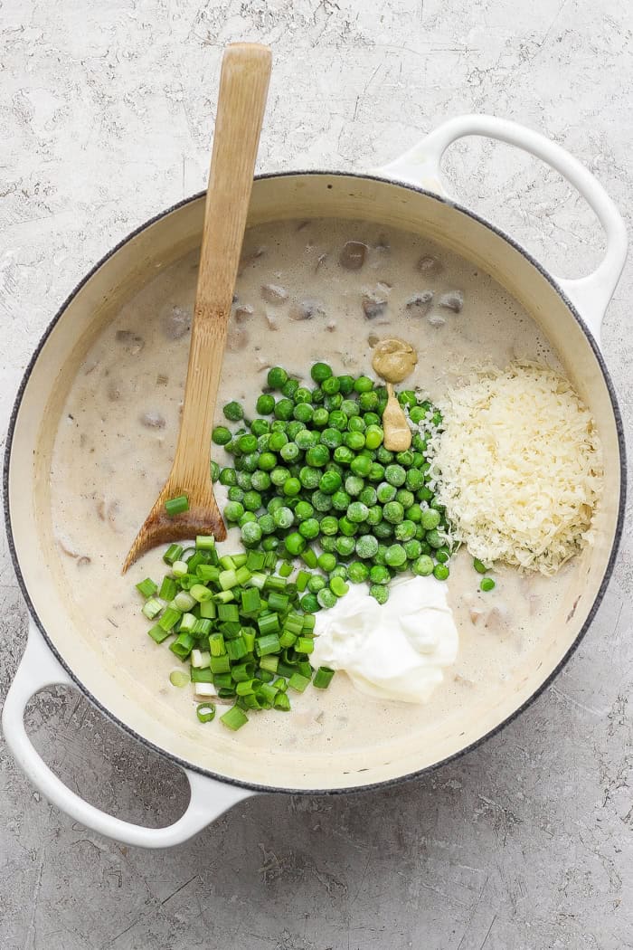 This sour cream and onion tuna noodle casserole is creamy, comforting and delicious. It’s an easy, nostalgic dinner with a bold flavor twist! Peas, sour cream, Dijon, and Parmesan added to Dutch oven with creamy sauce.
