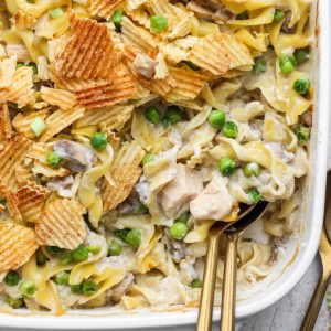 Two spoons in dish of sour cream and onion tuna noodle casserole.