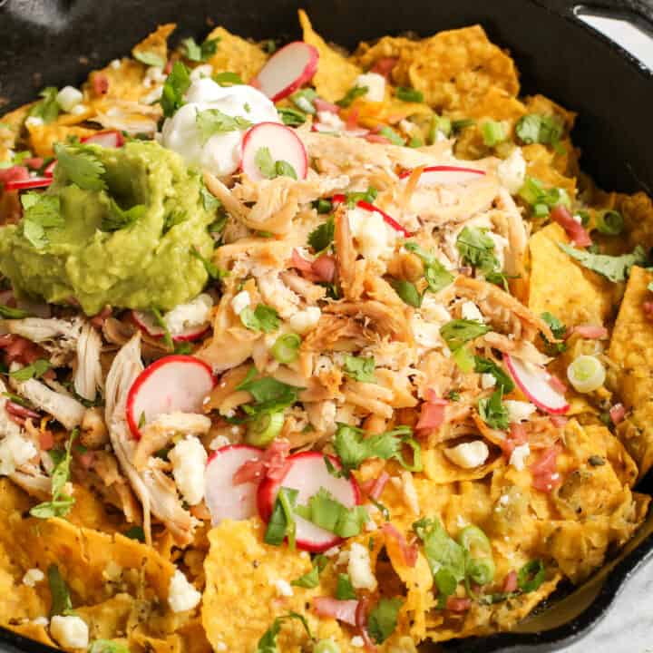 Skillet chilaquiles verdes topped with chicken and sliced radishes
