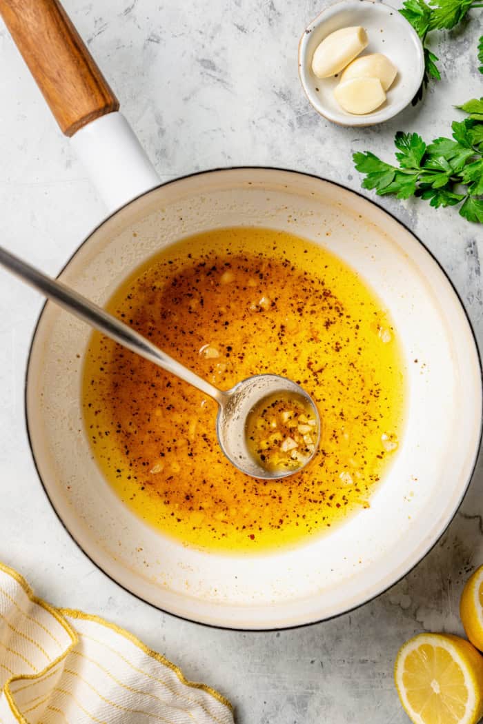 These Grilled Lemon Pepper Chicken Skewers are an easy summer recipe that's super fast for a weeknight. Don't skip the lemon butter sauce! Lemon pepper butter sauce in pan with spoon