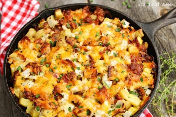 potatoes, bacon, cheese, and herbs in a cast iron skillet