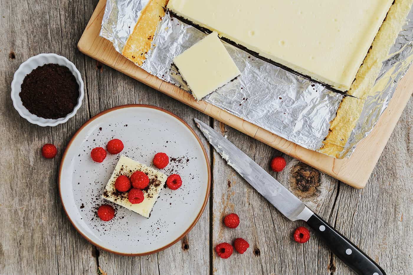 White chocolate cheesecake bars with a row cut and one bar on a white plate