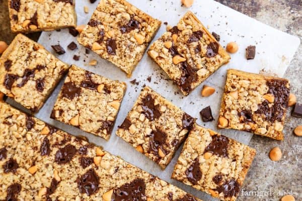 Top view of butterscotch chocolate chunk blondie squares on a sheet of parchment