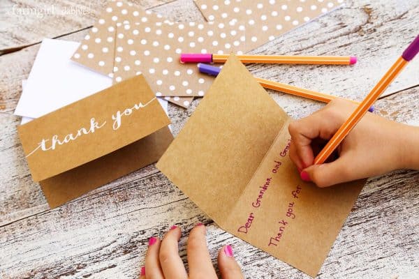 a girl writing a thank you card