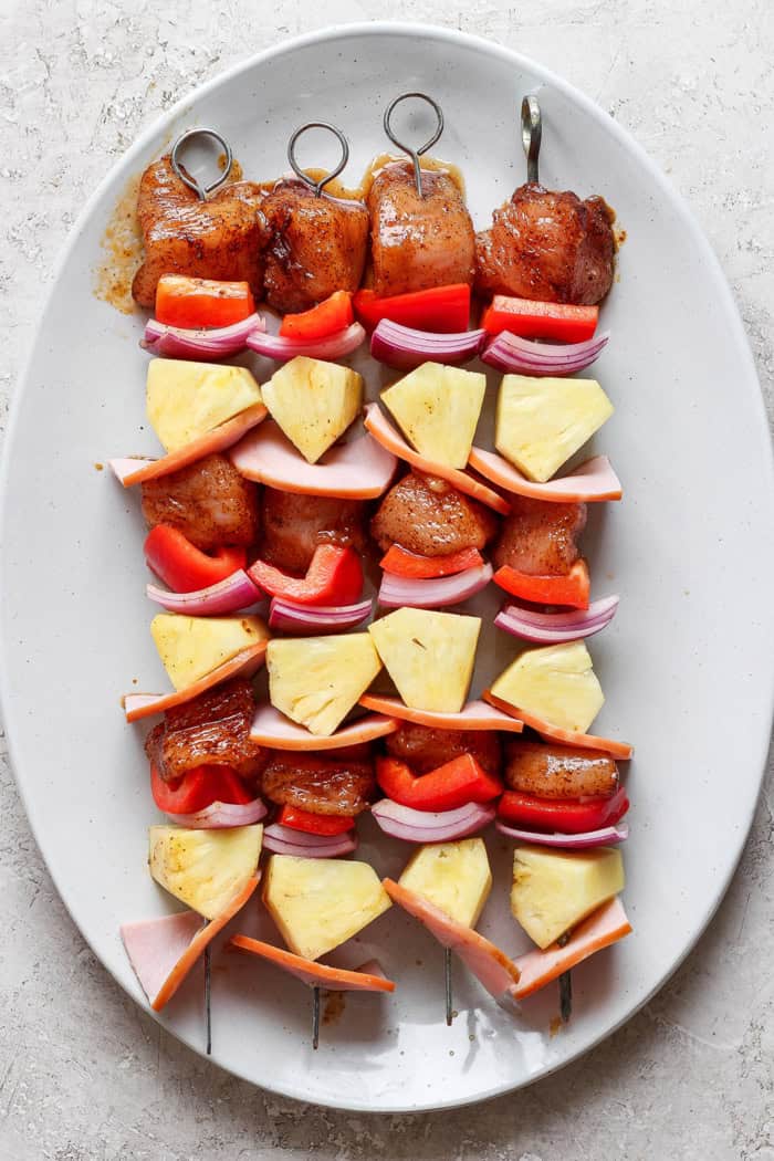Overhead view of Hawaiian chicken chili kabobs on platter before grilling