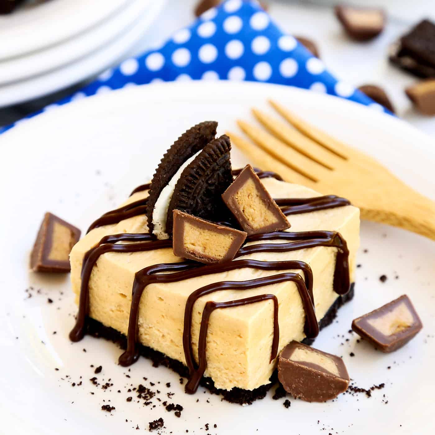 A no bake chocolate peanut butter  bar on a white plate topped with candy