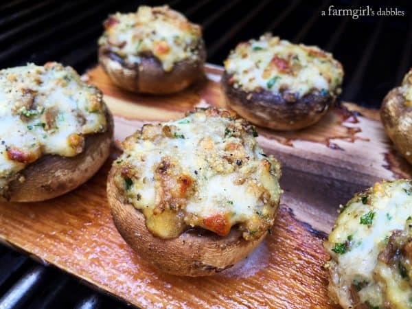 Stuffed mushrooms with melted cheese on a cedar plank