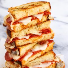 A stack of pepperoni pizza grilled cheese halves.