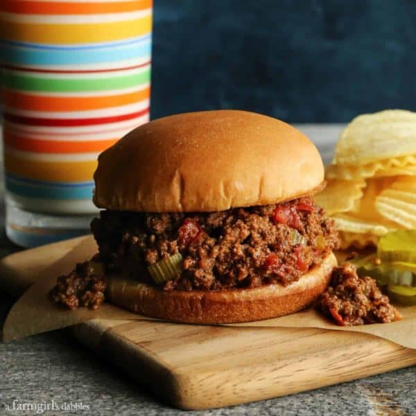 sloppy joes sandwich with potato chips and pickles