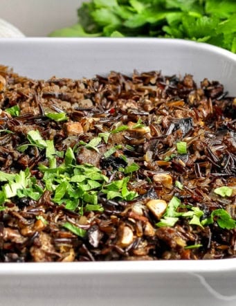 Wild rice casserole with mushrooms and sausage in baking dish.