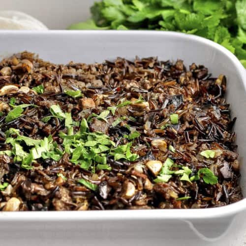 Wild rice casserole with mushrooms and sausage in baking dish.