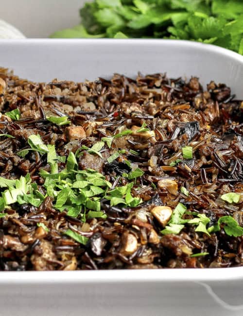 Wild rice casserole with mushrooms and sausage in baking dish.