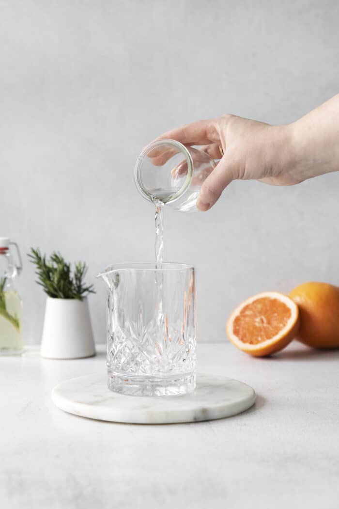 A shot of vodka being poured into a cocktail glass